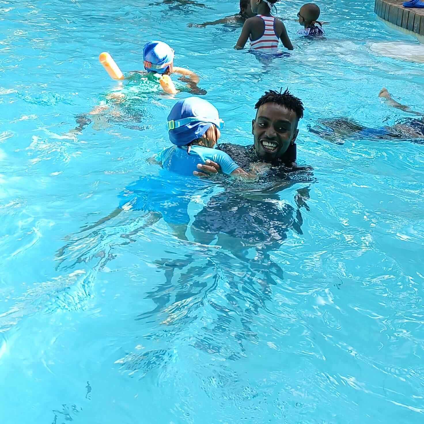 Tiny tots smiling and practicing bubbles in the pool